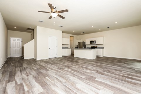 A spacious room with a ceiling fan and lighting fixtures.