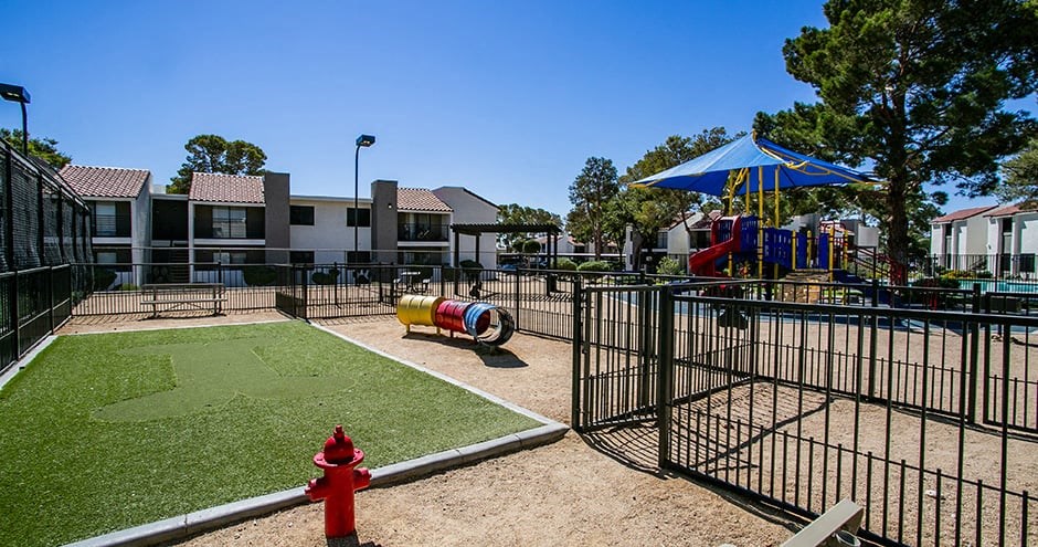 a fenced in play area with a red fire hydrant