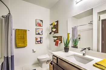 Luxurious modern bathrooms featuring quartz countertops with square sinks, rain shower heads, designer cabinetry and hardware