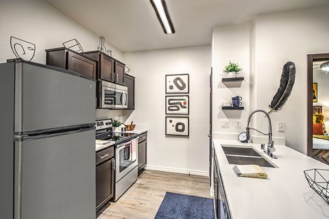 a kitchen with stainless steel appliances and a sink and a refrigerator