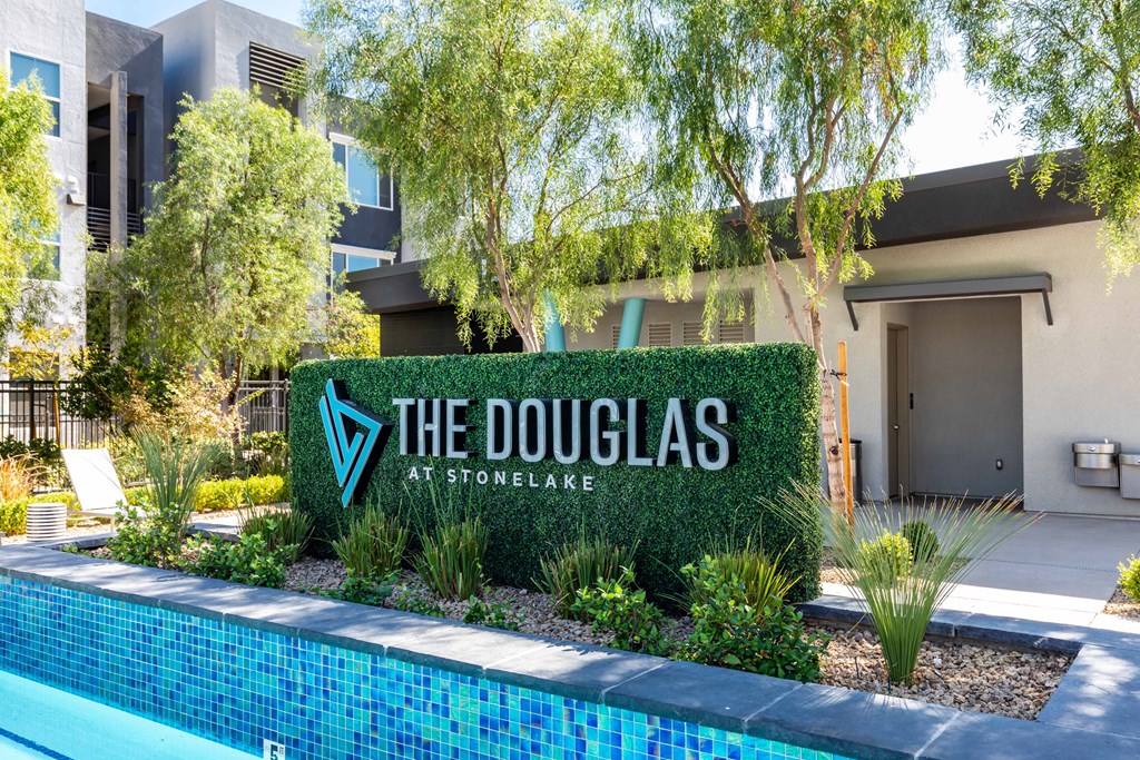 the douglass at stonewall apartments sign in front of a pool