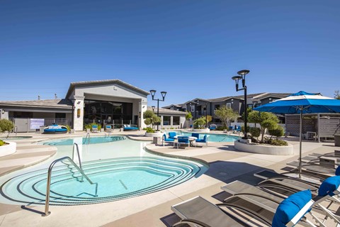 A large outdoor swimming pool with a diving board and lounge chairs.