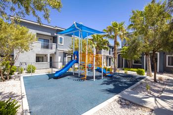 A playground with a blue slide and a yellow swing set.