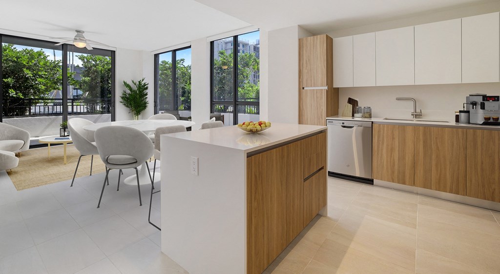 a kitchen with a large island and a dining room with a table and chairs