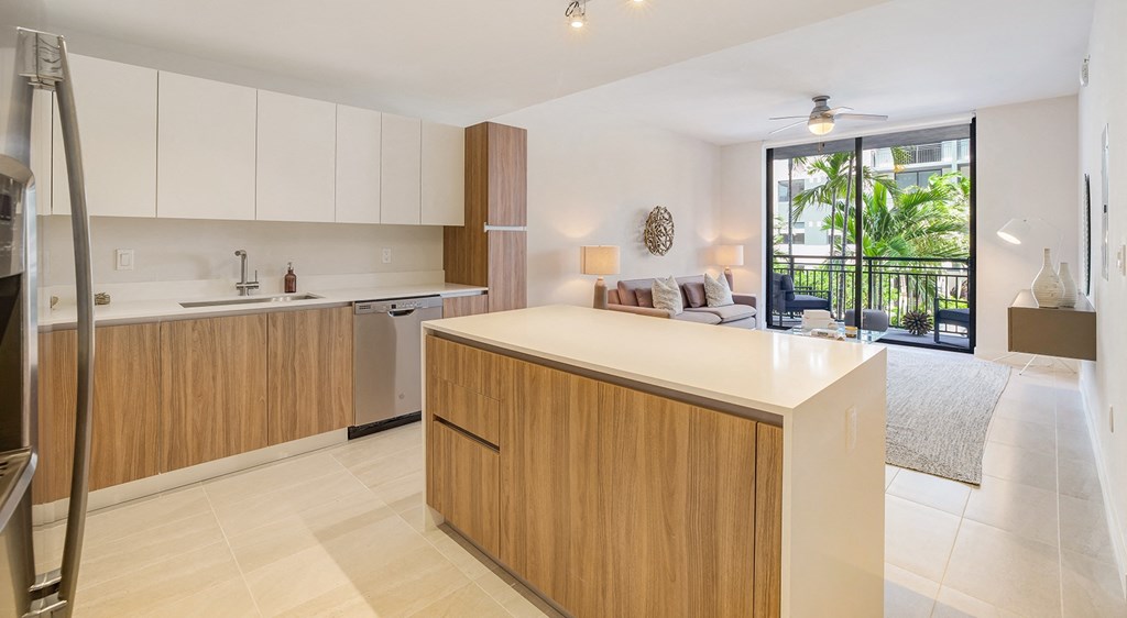 a modern kitchen with a large island and a living room