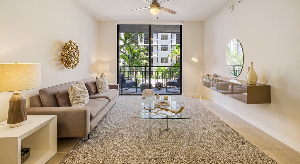 a living room with a couch and a sliding glass door to a balcony