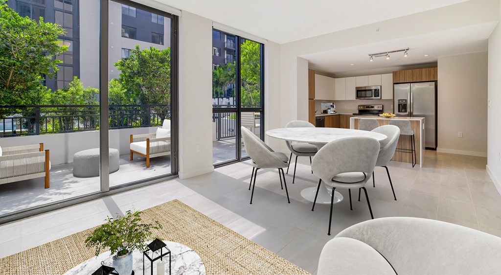 a living room with a table and chairs and a balcony