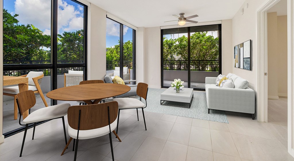 a living room with a table and chairs and a balcony