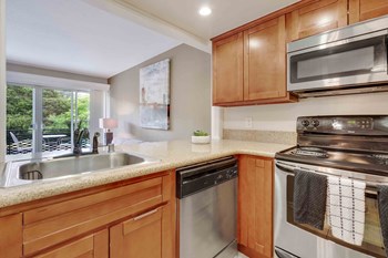 Los Gatos CA Apartments for Rent - El Gato Penthouse - Kitchen with Wood-Style Cabinets, Stainless Steel Appliances, and Beige Granite Countertops - Photo Gallery 4