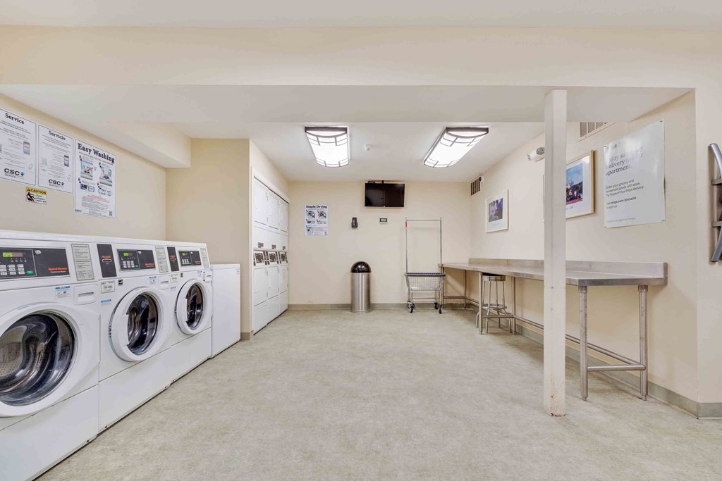 Los Gatos, CA, Apartments Near Stanford - El Gato Penthouse - Spacious Laundry Room with Washers, Dryers, Trash Can, and Long Table.