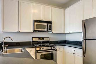 Kitchen with white cabinets and stainless steel appliances - Photo Gallery
