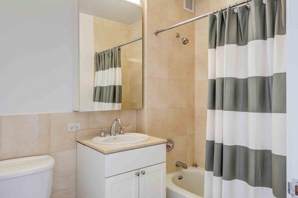 Model apartment bathroom with vanity and tub shower