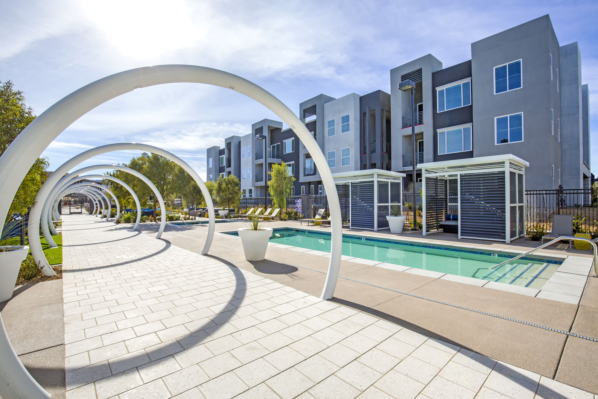 modern apartment buildings with a pool and arch structures