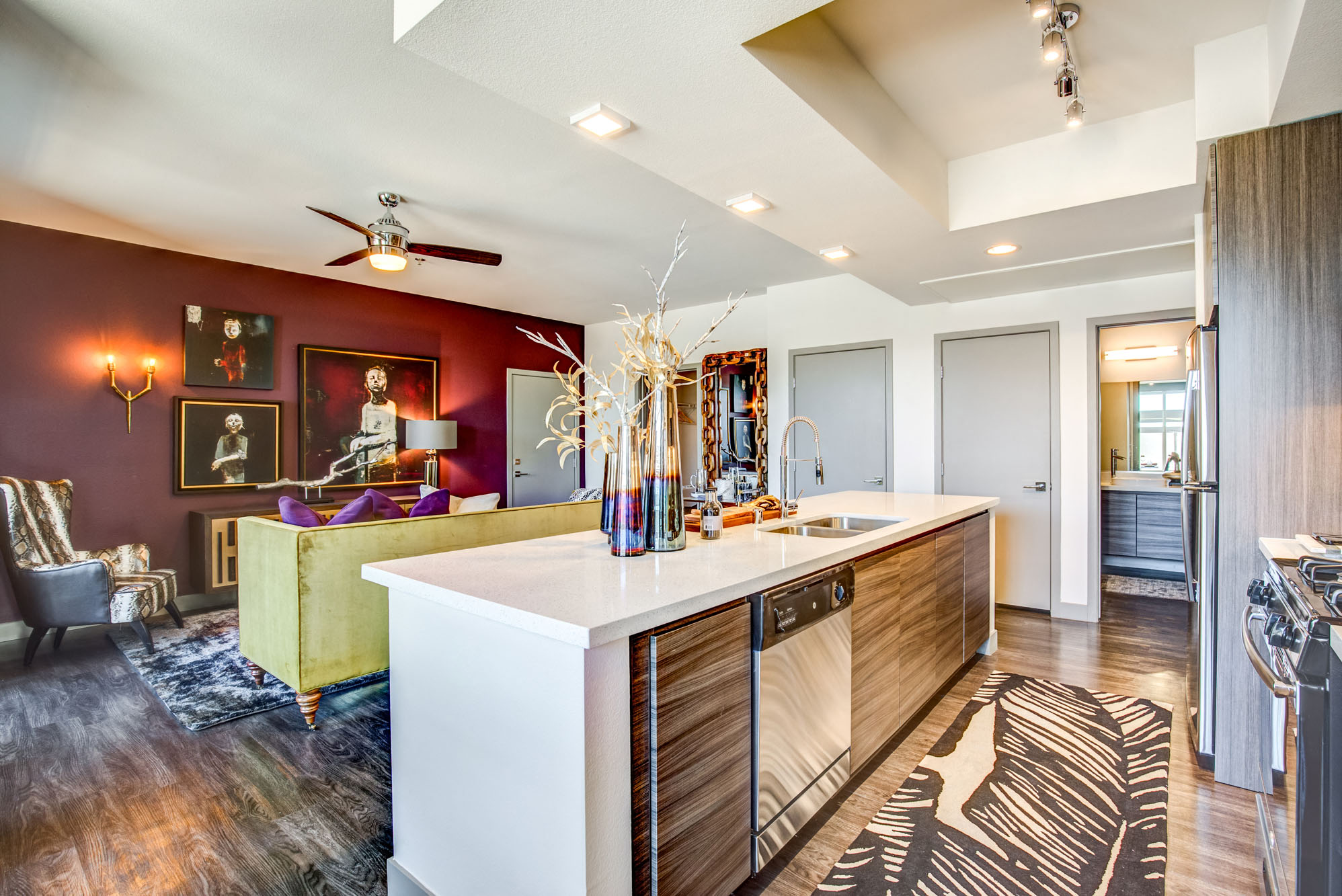 a kitchen with a white counter top and a living room with a couch
