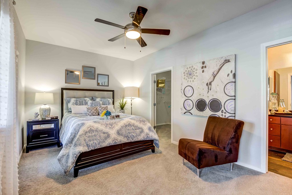a bedroom with a bed and a ceiling fan
