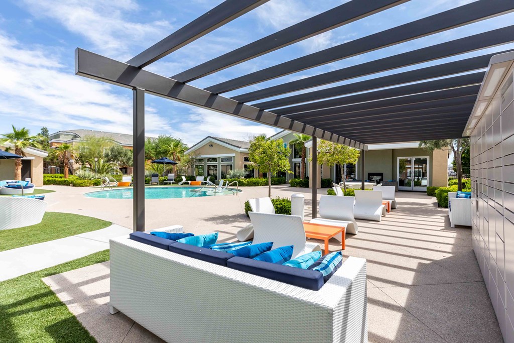a patio with white furniture and a swimming pool