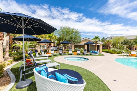 a patio with chairs and umbrellas and a swimming pool