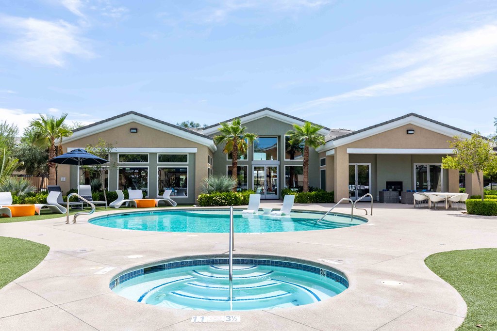 a pool and patio with a house in the background