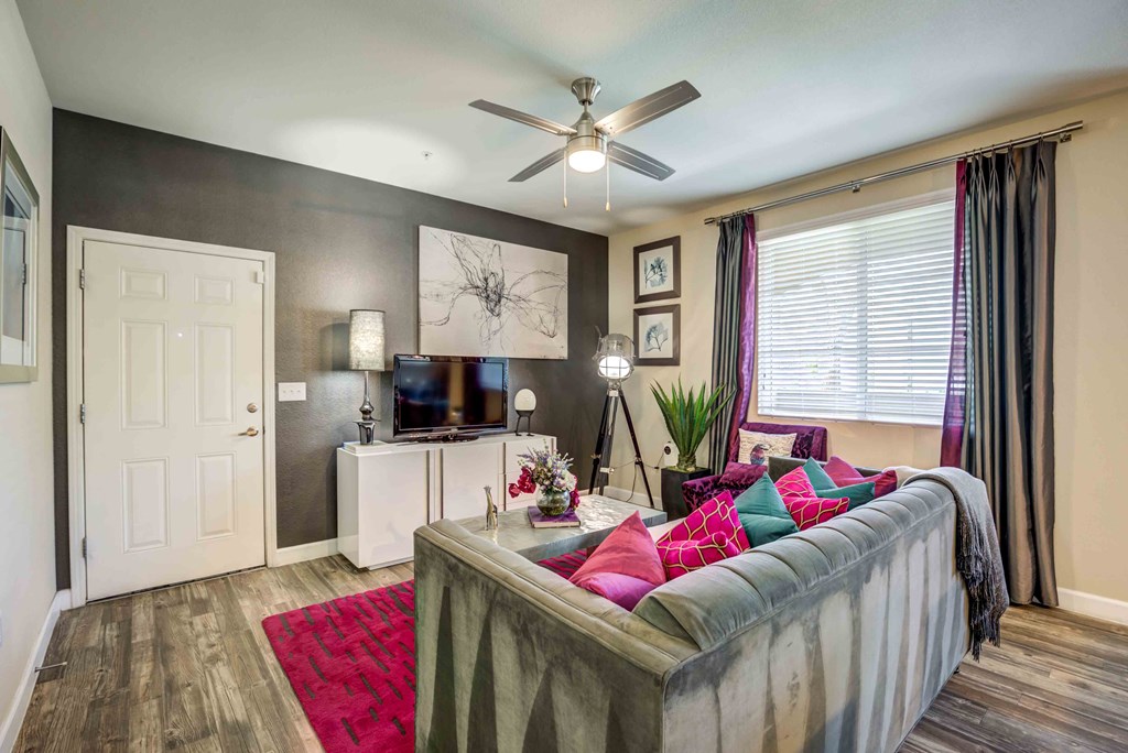 a living room with a couch and a ceiling fan
