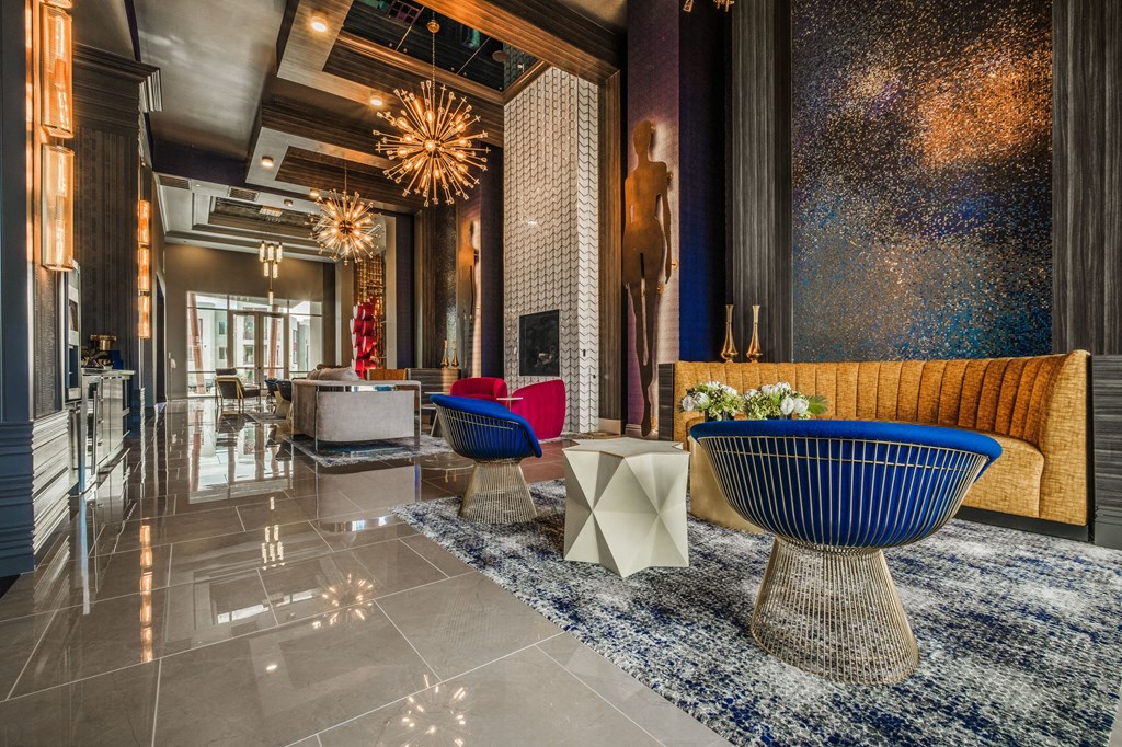 a lobby with blue and yellow chairs and a blue rug