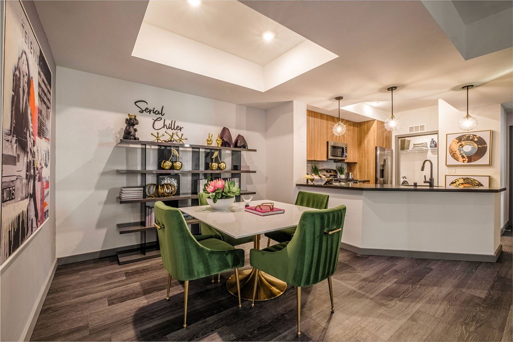 a dining room with a white table and green chairs