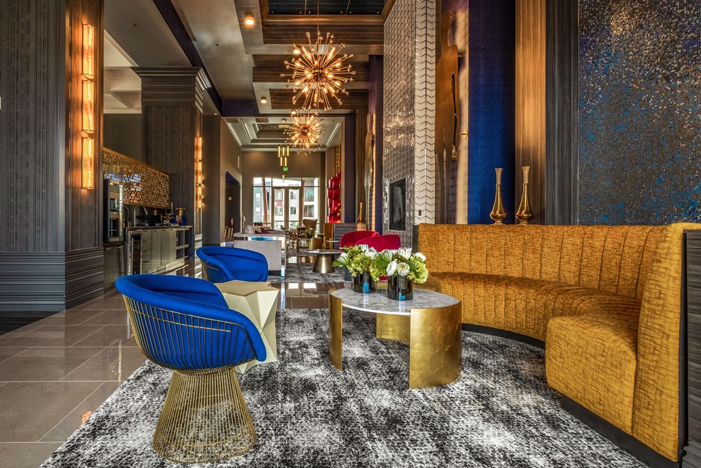 the lobby of a hotel with yellow couches and blue chairs