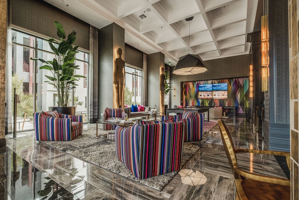 a lobby with chairs and tables and large windows