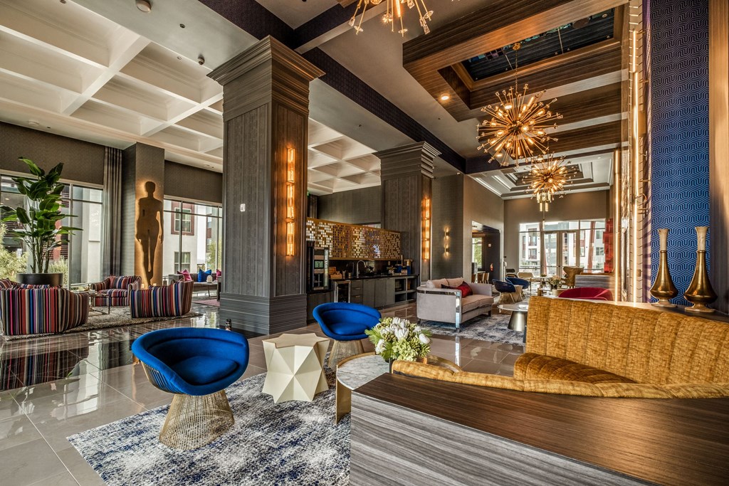 a lobby of a hotel with blue chairs and couches