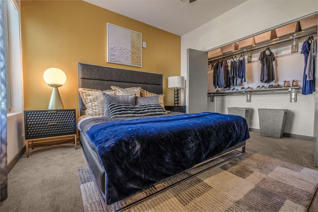 a bedroom with a large bed and a closet with clothes rails