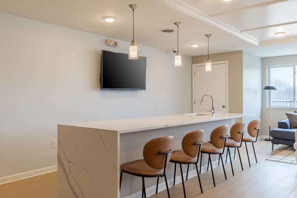 A modern living room with a bar and chairs.