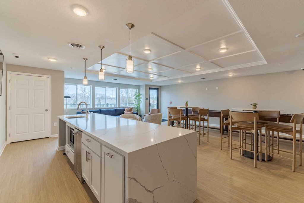 A kitchen with a marble island and wooden floors.
