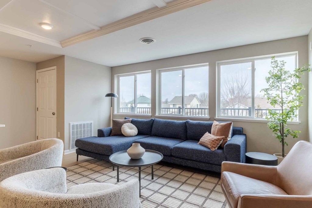 A living room with a blue couch and a round table.