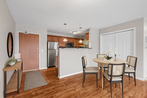 a dining room with a table and chairs and a kitchen with a refrigerator