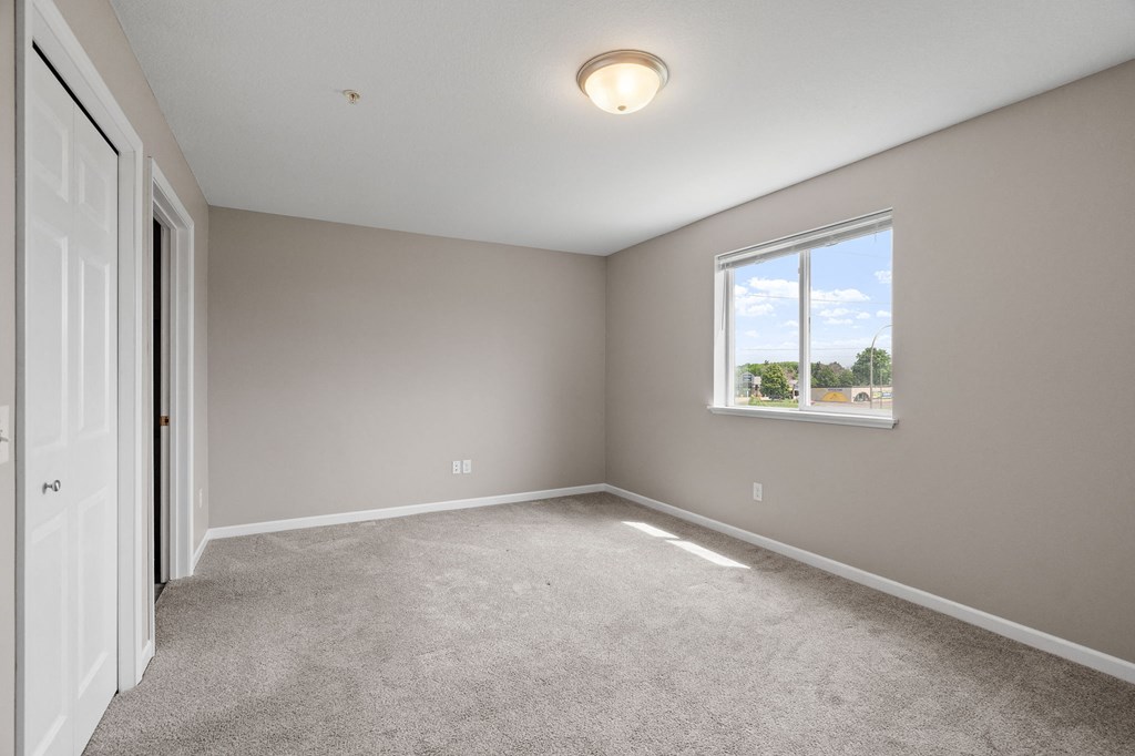 an empty room with carpet and a window
