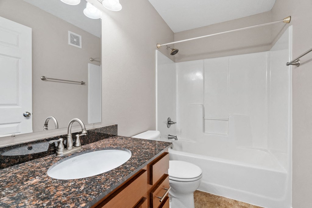 a bathroom with a sink and a shower and a toilet