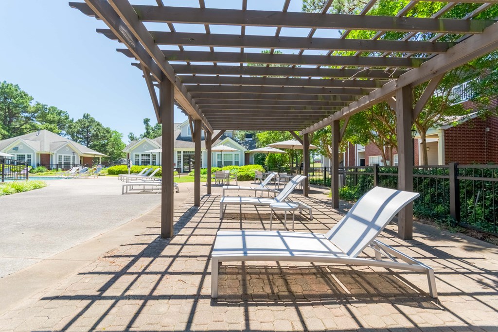 elaxing poolside lounge with pergola seating at Enclave at Wolfchase Apartments.