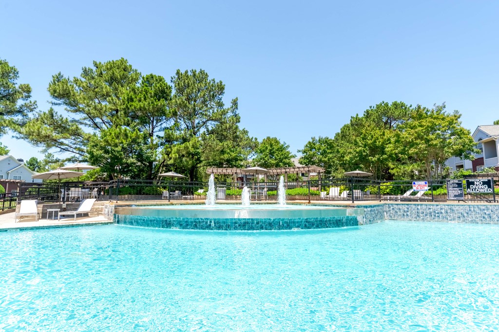 Sparkling outdoor swimming pool with sundeck at Enclave at Wolfchase Apartments in Cordova, TN.