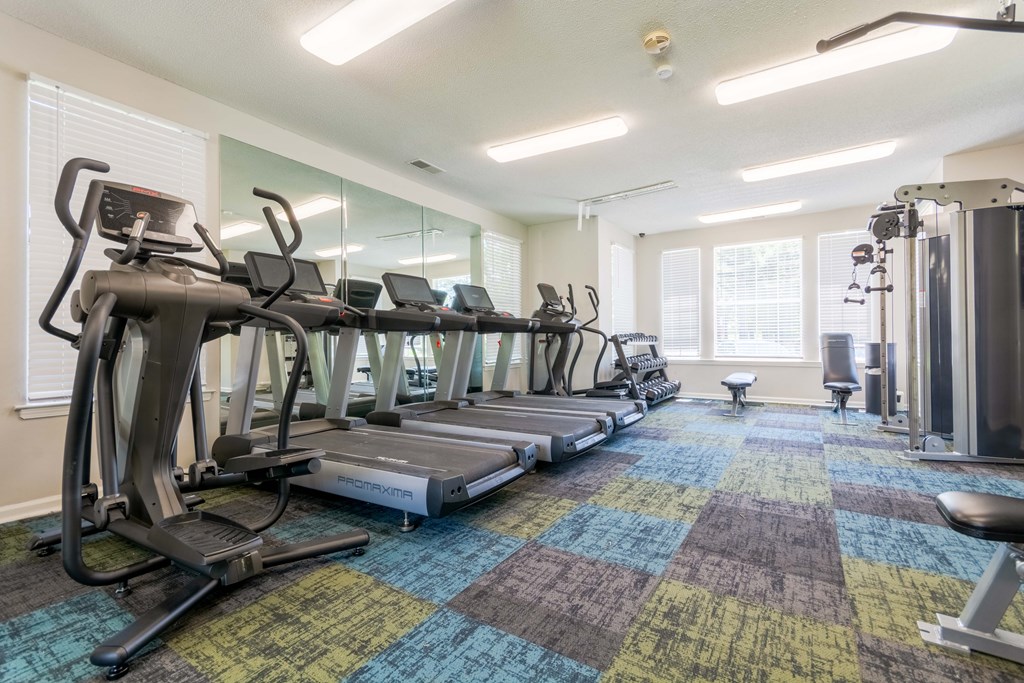 Cardio machines and treadmills in fitness center at Enclave at Wolfchase Apartments.