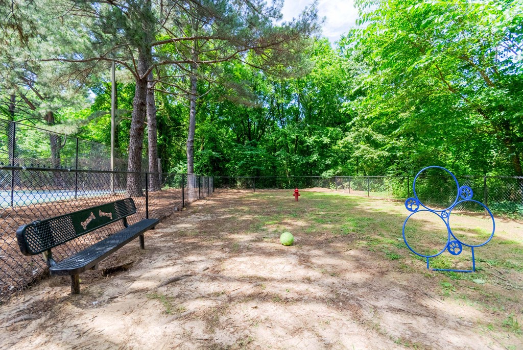 Leash-free dog park with shaded seating at Enclave at Wolfchase – pet-friendly apartments in Cordova, TN.