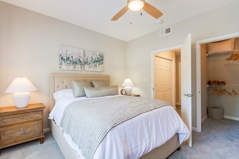 A bedroom with a large bed and a painting on the wall.