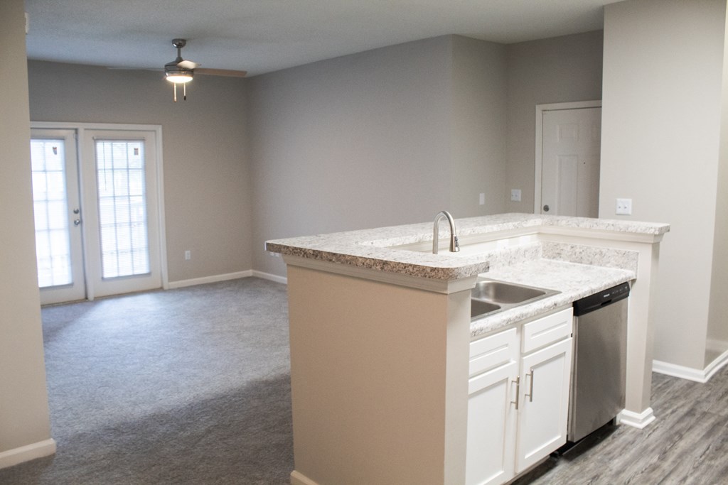 Enclave at Wolfchase Apartments in Cordova Tennessee photo of a kitchen with an island and an empty living room in the background