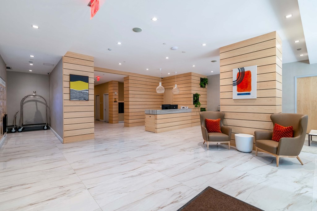 the lobby of a hotel with chairs and a desk