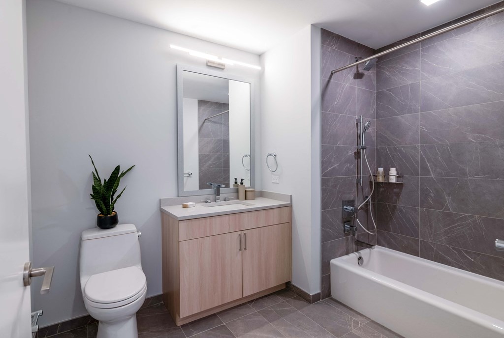 a bathroom with a toilet sink and shower and a mirror