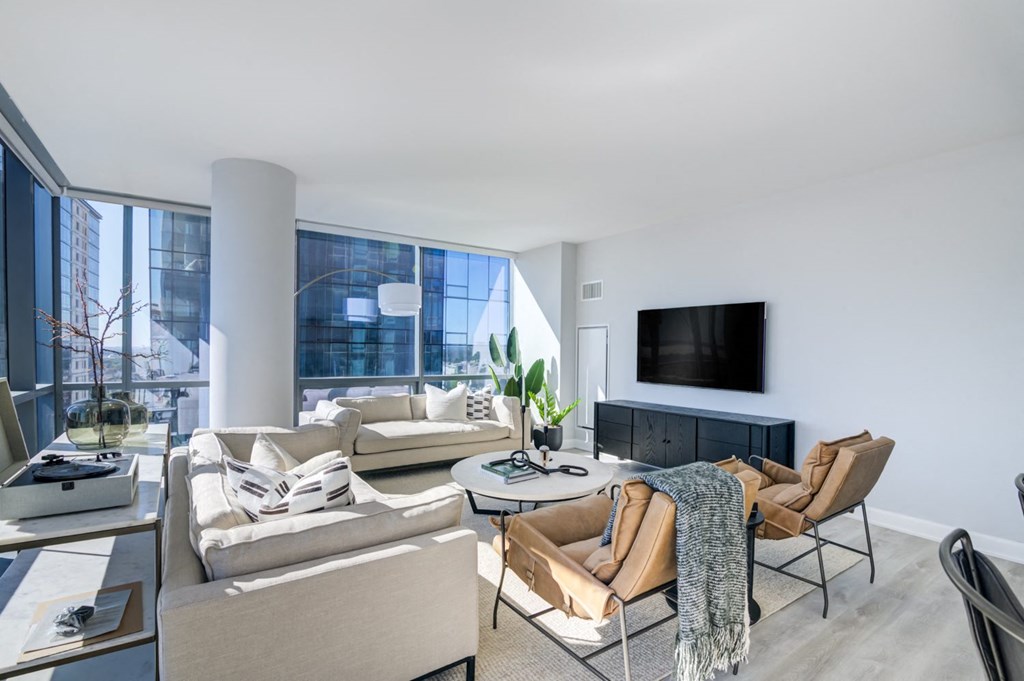 a living room with a large window and a couch and a tv