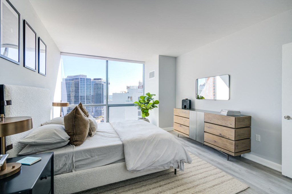 a bedroom with a bed and a large window