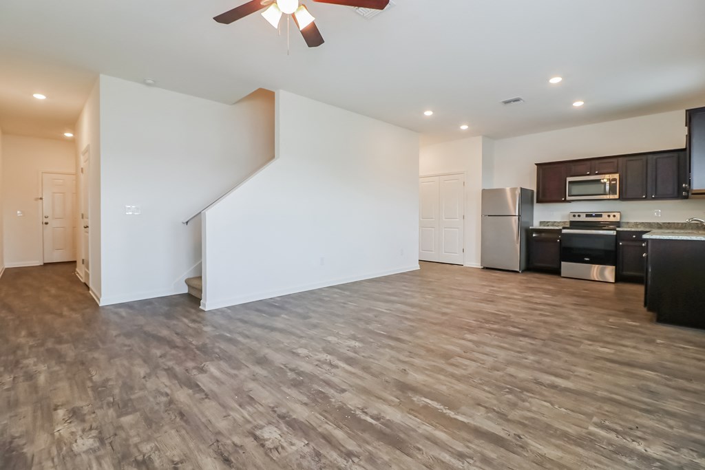 A spacious kitchen with a refrigerator, microwave, and oven.