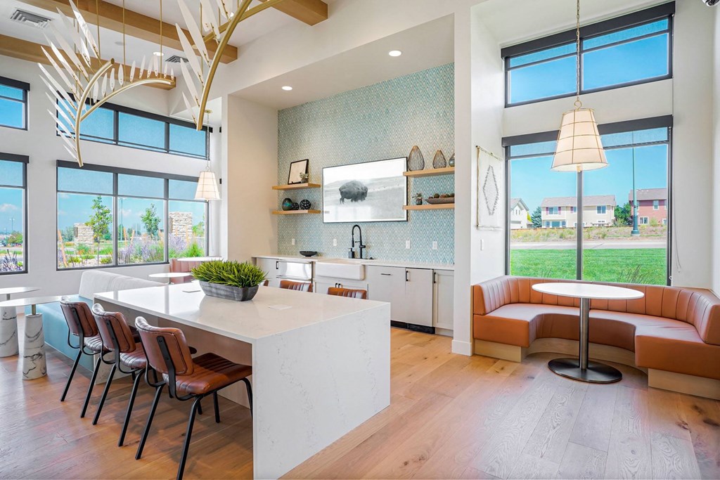 a kitchen with a white counter top and a table with chairs