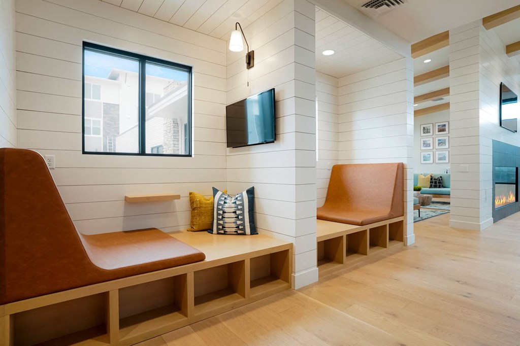 a seating area with two benches and a television in a room with white walls