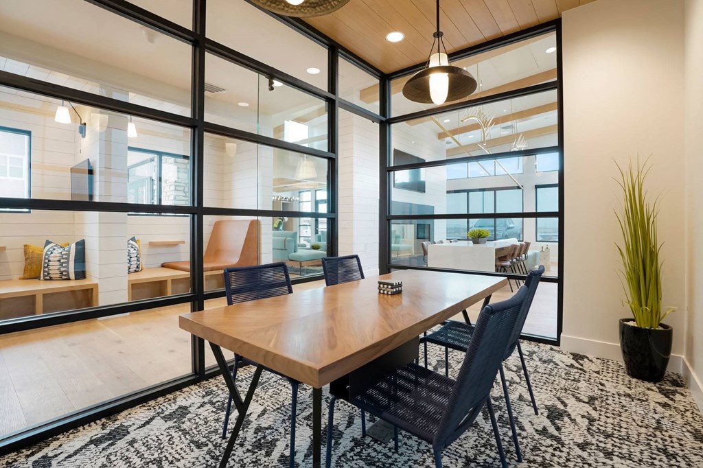 a conference room with large windows and a wooden table and chairs