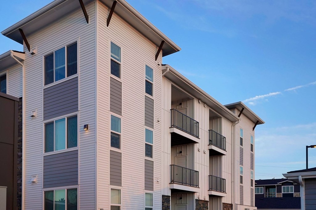 an apartment building with balconies and a blue sky